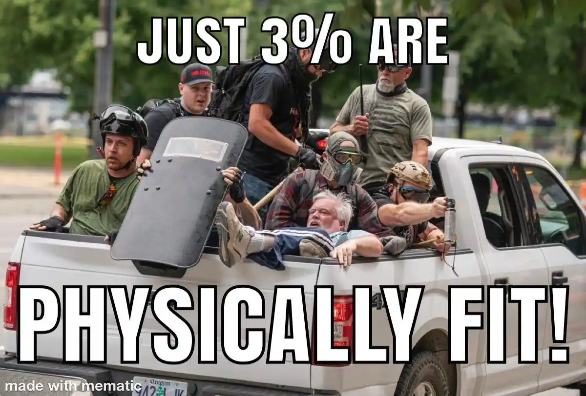 A white pickup truck is filled with men in tactical gear, including helmets, face masks, and a riot shield. One man is lying…