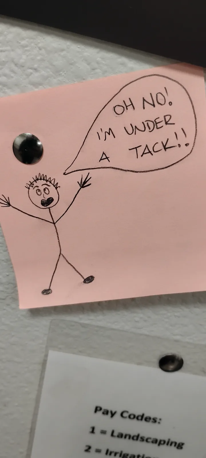 A pink sticky note has a simple stick figure drawing with a speech bubble that reads 'OH NO! I'M UNDER A TACK!!'. The note…