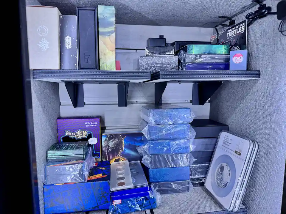 A densely packed display case filled with numerous collectible coin boxes and cases, including Star Wars, Teenage Mutant…