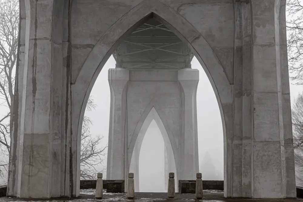 The image shows a series of five identical photos of a misty, gothic-style stone bridge archway, arranged in a grid. The…