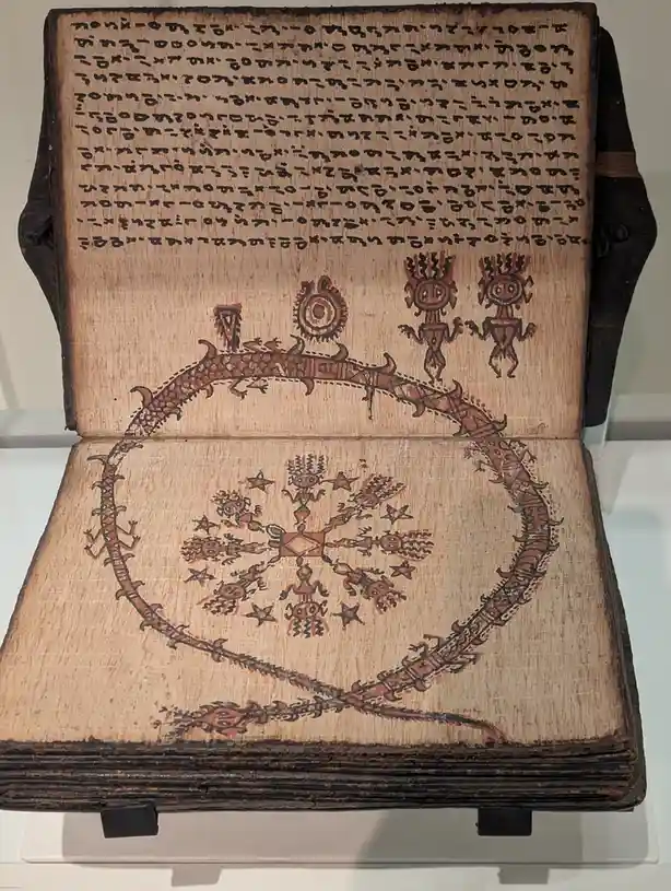 an open, aged book with brownish pages displays intricate, ancient-style drawings in reddish-brown ink, including stylized…