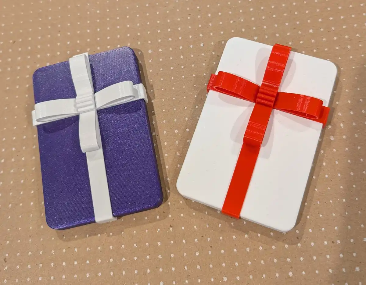 Two notebooks, one purple with a white ribbon and one white with a red ribbon, are arranged side by side on a brown…