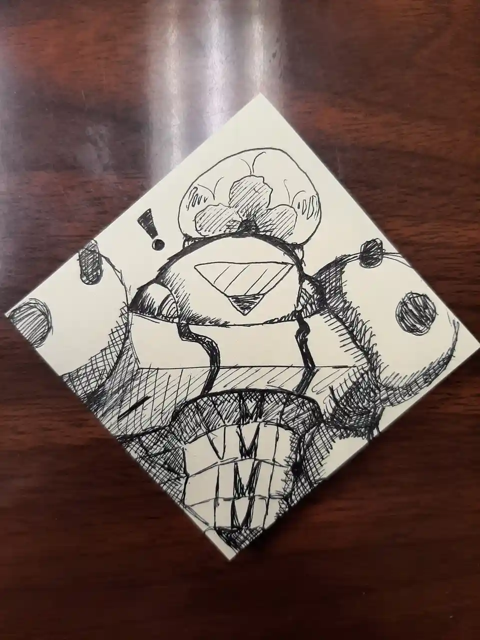 A hand-drawn black-and-white sketch on a square piece of paper shows a cartoonish, muscular character wearing a chef's hat…