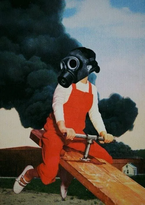A child in red overalls and white shirt rides a wooden seesaw, wearing a black gas mask, with thick black smoke billowing…