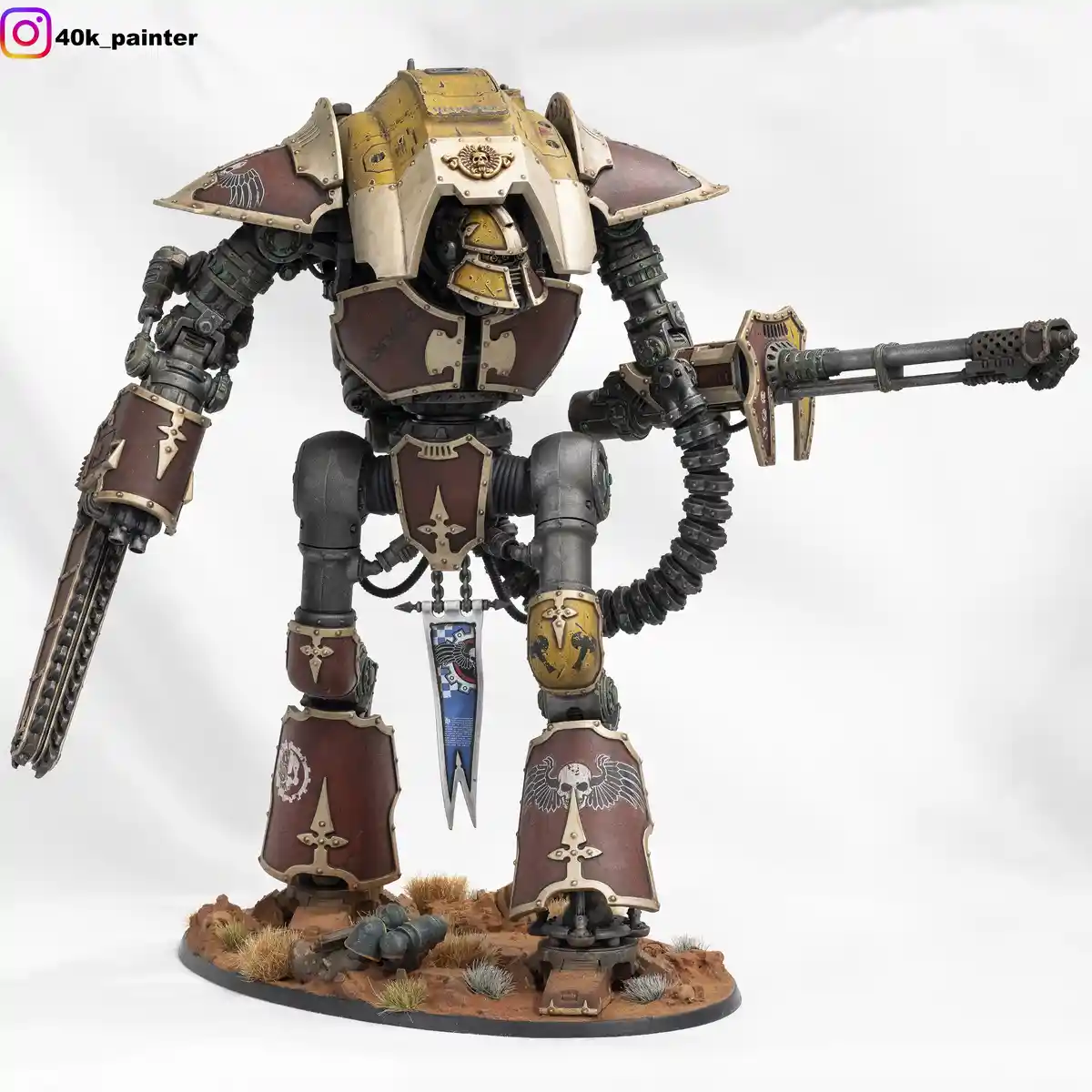 A highly detailed, painted miniature of a Warhammer 40,000 Ultramarine Space Marine Dreadnought stands on a desert-like…