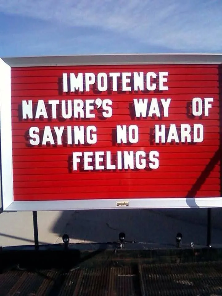 A red, wooden-framed sign with white letter tiles displays the text 'IMPOTENCE NATURE'S WAY OF SAYING NO HARD FEELINGS'…