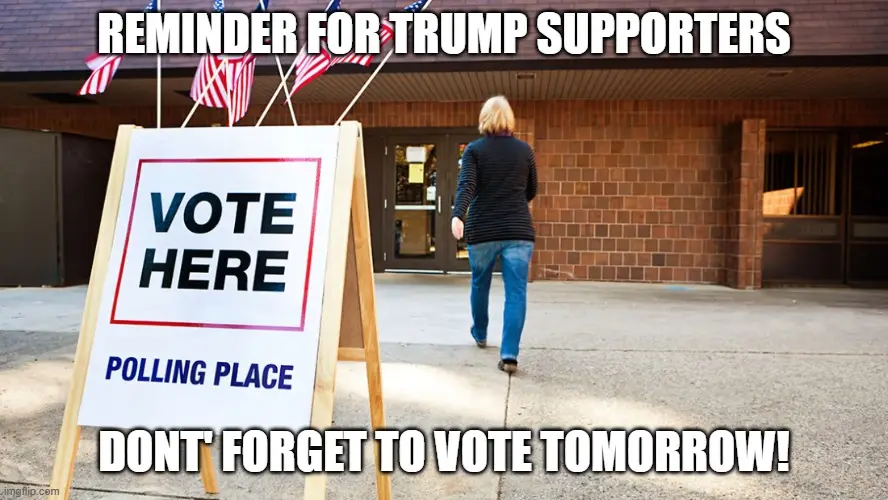 A person walks away from a brick building toward a glass door, with a wooden A-frame sign in front of them that reads 'VOTE…