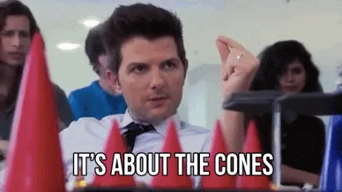 A repeating image of actor David Schwimmer in a white shirt and tie, seated at a table with red party cones in front of him…