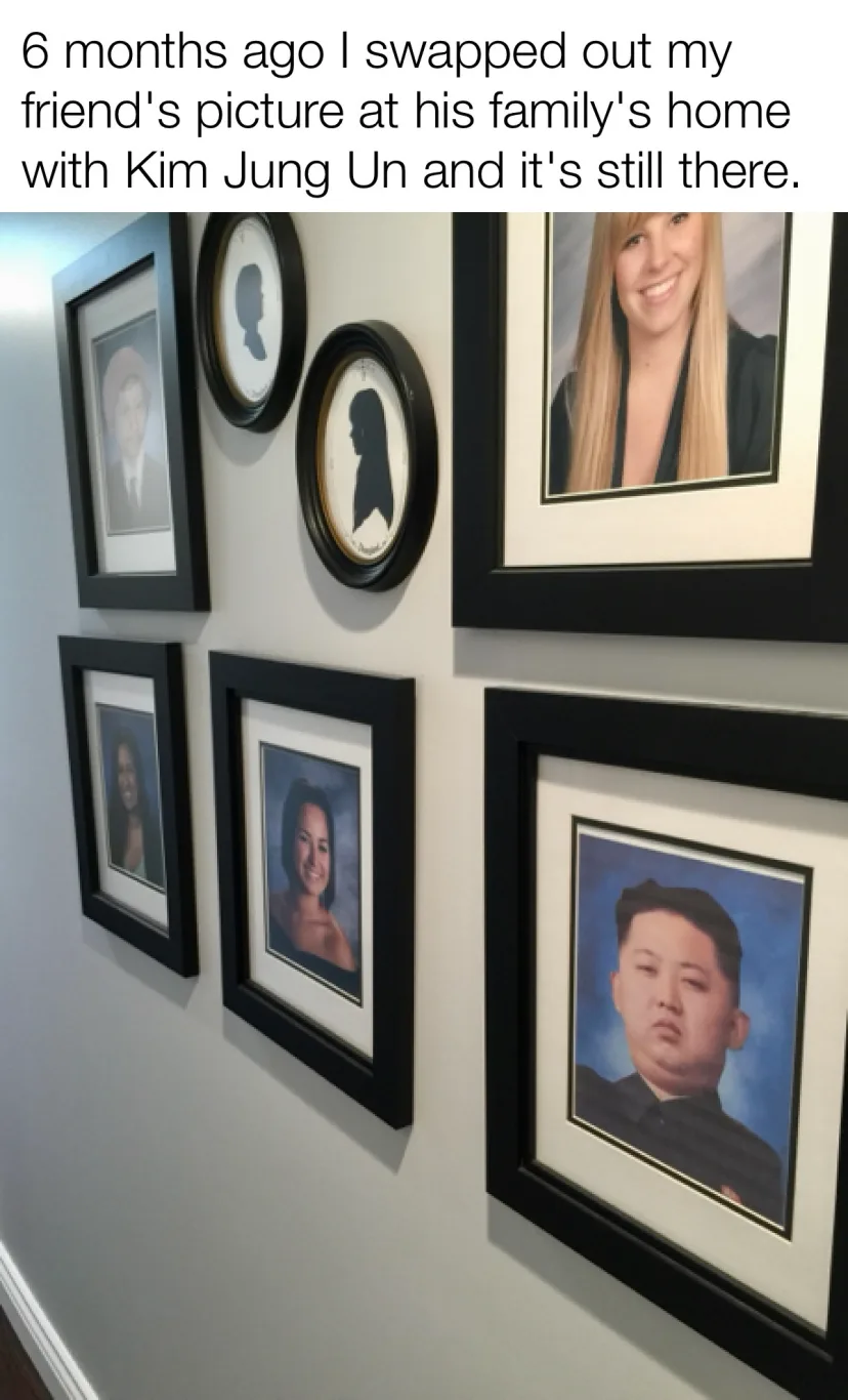 A wall displays several framed portraits, including silhouettes and photos of people, with one photo replaced by a portrait…