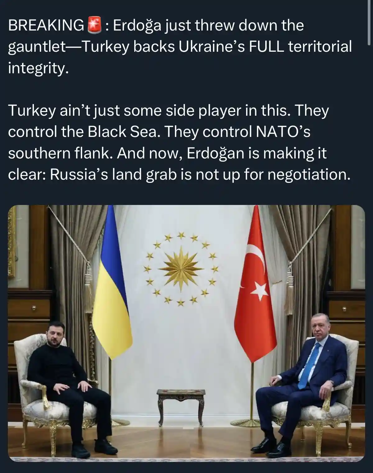 Two men sit in ornate chairs facing each other, flanked by Ukrainian and Turkish flags, with a NATO emblem behind them. The…