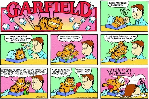 A Garfield comic strip panel showing Jon waking up Garfield, who then proudly displays his 'stuff' including a brass lizard…