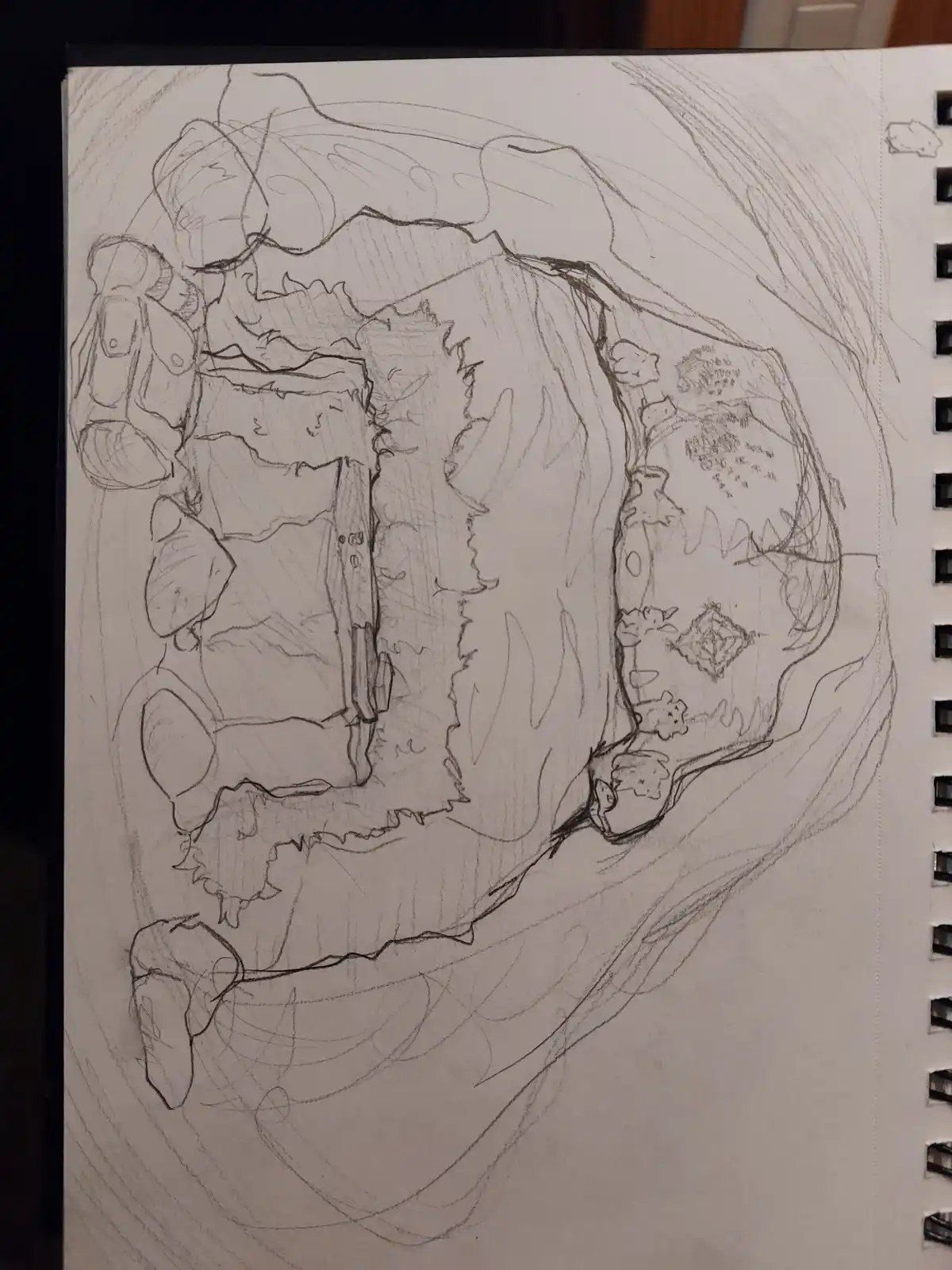 A pencil sketch on spiral-bound paper depicts a messy, abstract drawing that resembles a distorted, fragmented face or…
