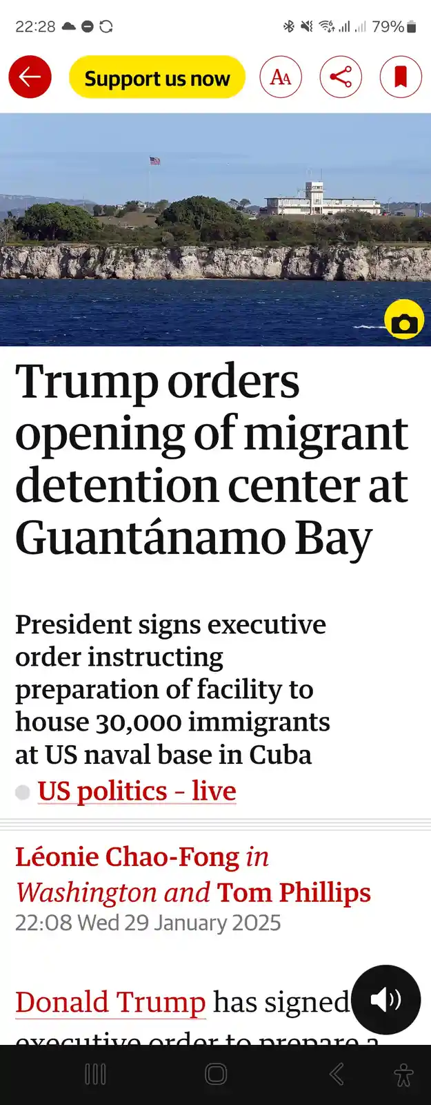 A screenshot of a news article headline on a mobile phone reading 'Trump orders opening of migrant detention center at…