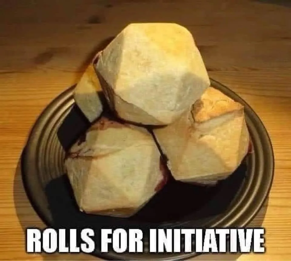 A bowl contains four geometrically shaped, faceted bread rolls resembling dice, sitting on a wooden table. The text overlay…