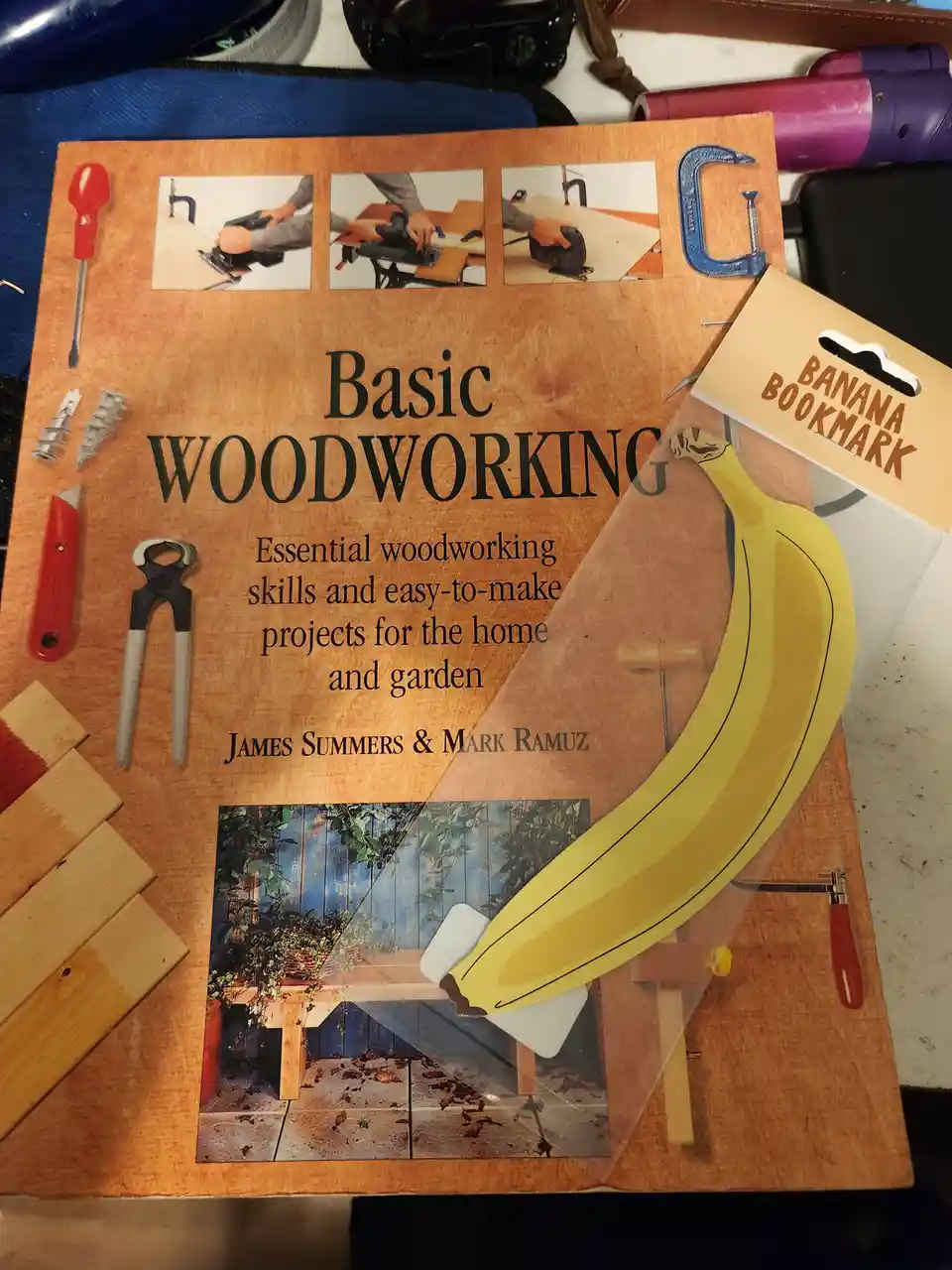 A 'Basic Woodworking' book cover is shown with various woodworking tools and images arranged around the title. A…
