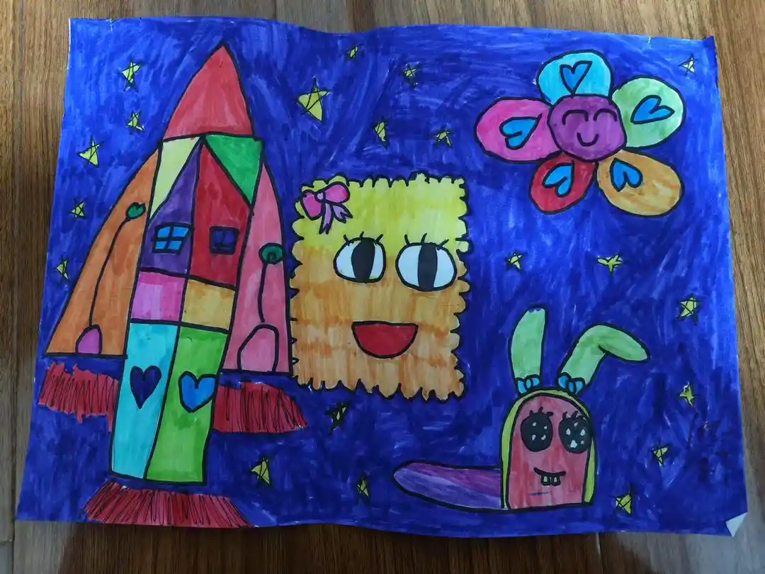 A child's colorful crayon drawing on paper shows a rocket ship, a fuzzy yellow creature with a bow, a smiling flower, and a…