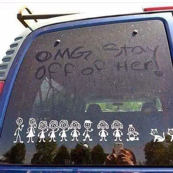 A blue car's rear window has handwritten text in black marker that reads 'OMG! STAY OFF OF HER!' Below the text, a row of…