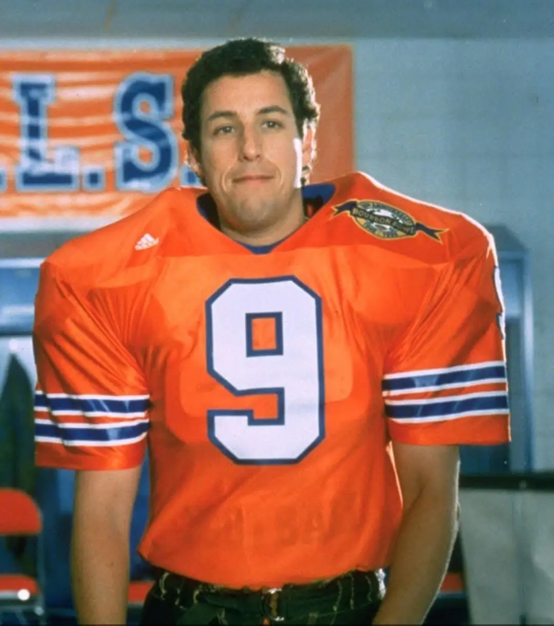 a man in an orange football jersey with the number 9 and a 'Bourbon Bowl' patch on the shoulder stands with a smug…