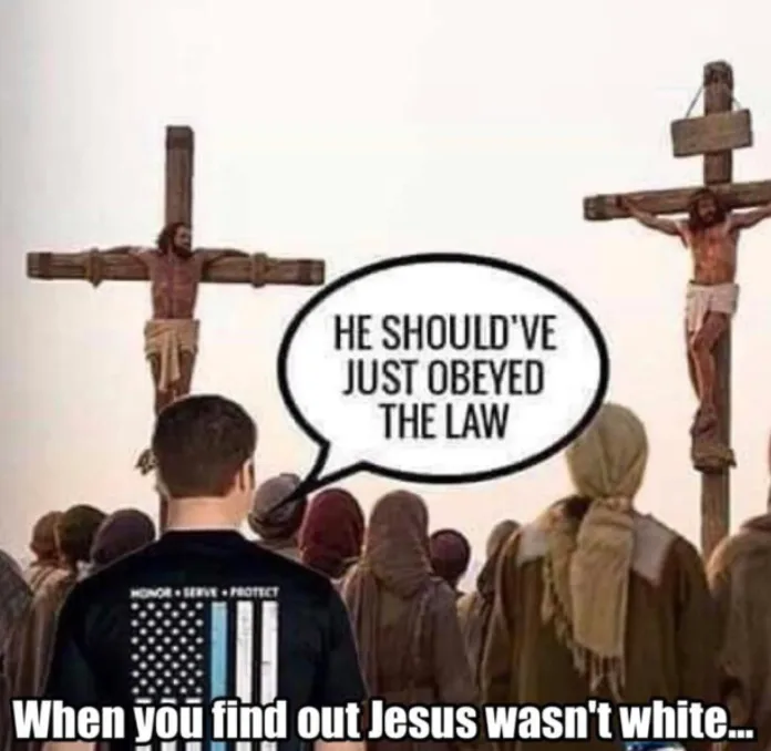 A man in a black t-shirt with an American flag and 'HONOR • SERVE • PROTECT' text on the back stands with his back to the…
