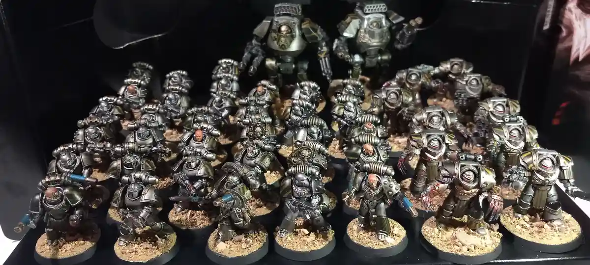 A large collection of painted, heavily armored miniature figures, resembling Space Marines from Warhammer 40,000, are…