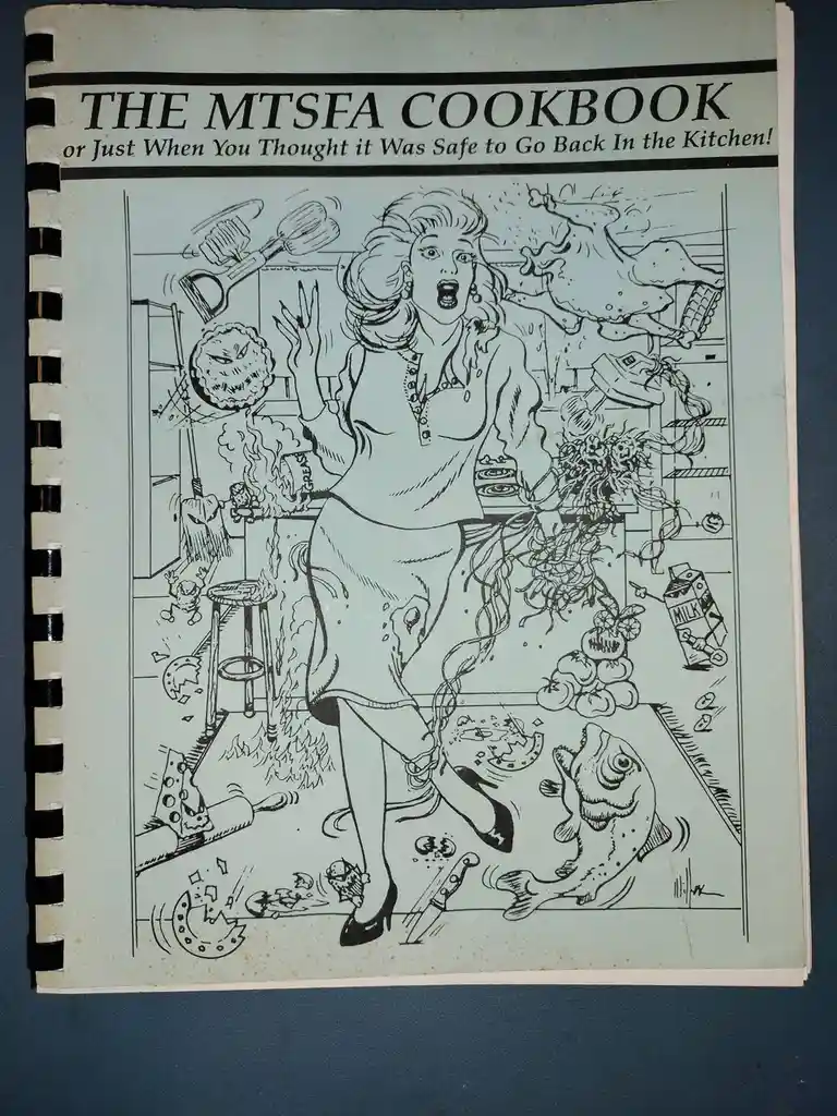 A black-and-white illustrated cookbook cover titled 'THE MTSFA COOKBOOK or Just When You Thought it Was Safe to Go Back In…