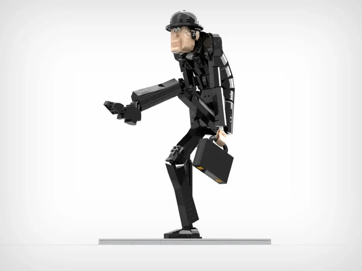 A LEGO minifigure constructed to look like a human man in a black suit and helmet, holding a briefcase and striking a…