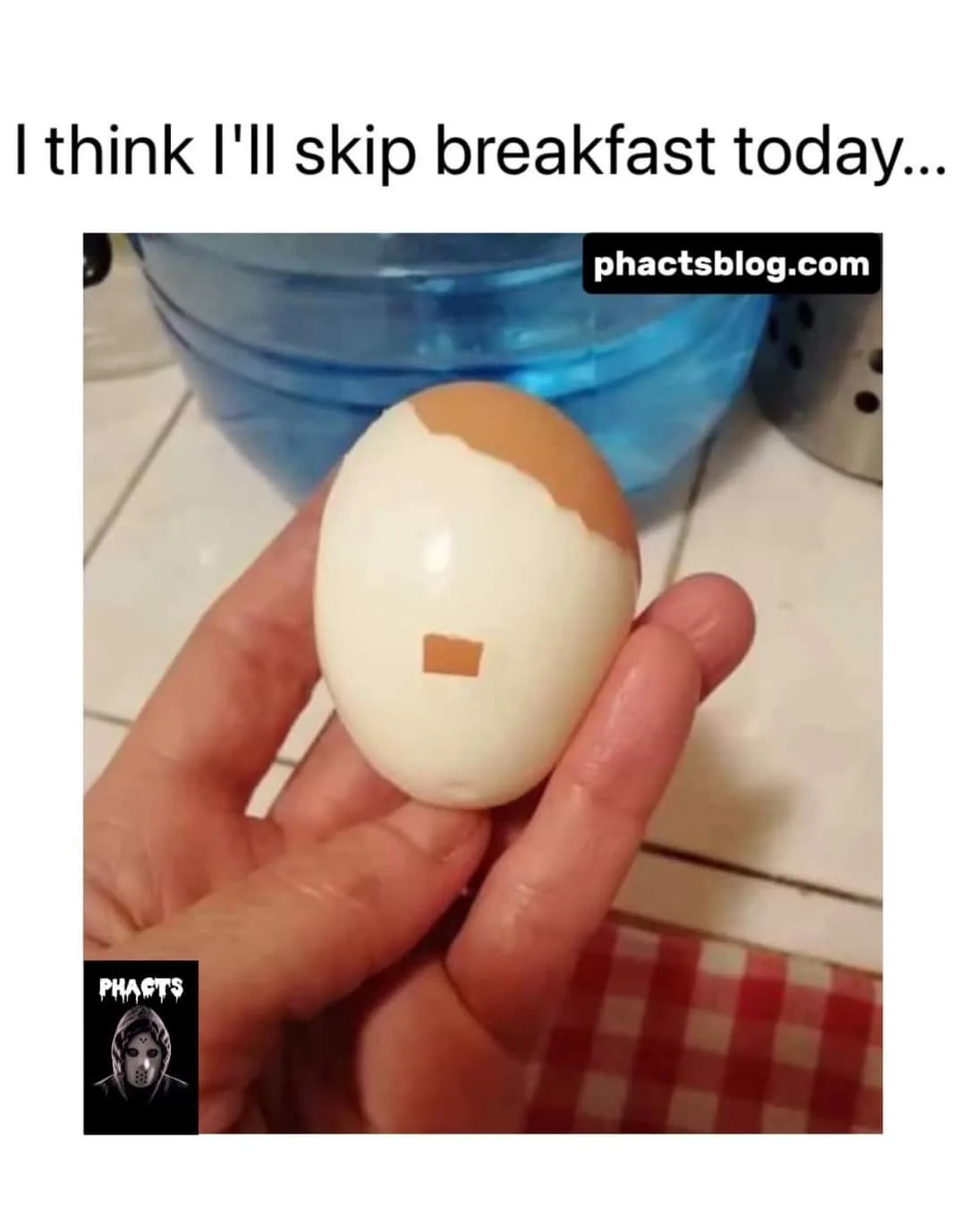 A hand holds a hard-boiled egg that has been peeled to resemble a face with a brown top half and a small brown rectangle on…