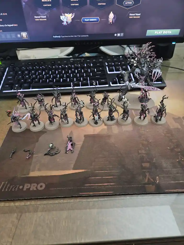 A collection of intricately painted fantasy miniatures, mostly resembling dark, tree-like humanoid figures with pink…