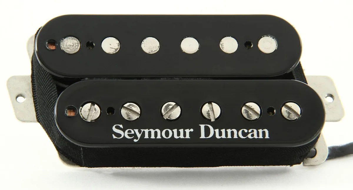 A close-up photo of two black Seymour Duncan humbucker guitar pickups, one with silver screws and the other with silver…