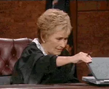 A sequence of six images shows a woman in a black robe, likely a judge, attempting to open a laptop. She struggles with the…