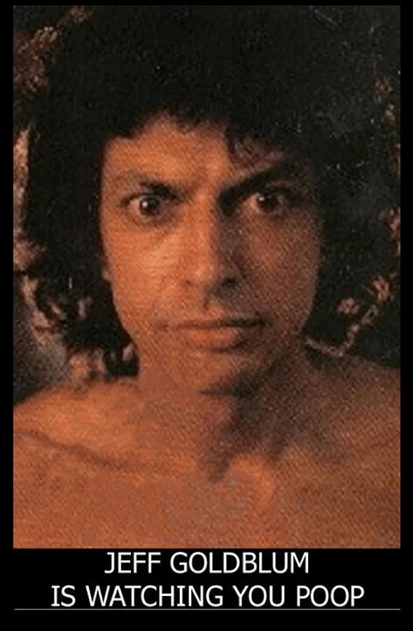 A grainy, orange-tinted photo shows actor Jeff Goldblum shirtless, staring intensely at the camera with wide eyes and a…