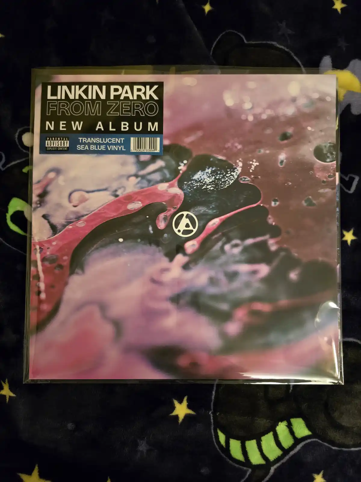 A sealed vinyl record sleeve for Linkin Park's album 'From Zero' is shown, featuring abstract pink, black, and purple swirls…