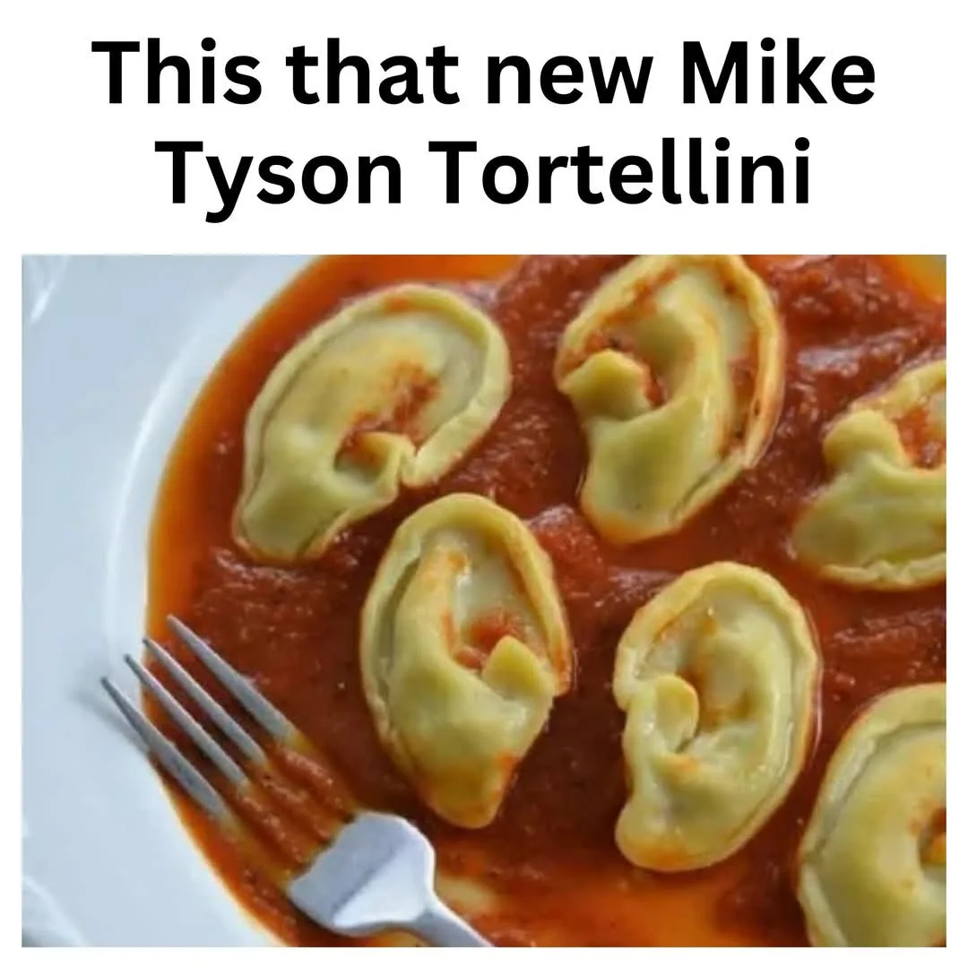 A close-up photo shows several tortellini pasta shapes, resembling human ears, floating in red tomato sauce on a white plate…