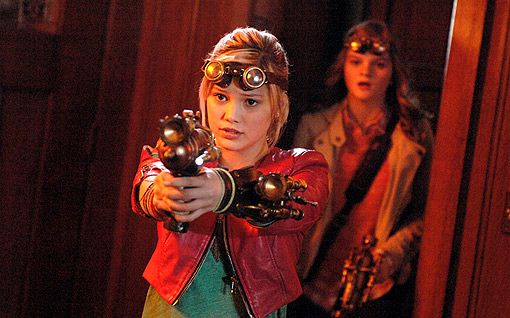 A young woman in a red jacket and goggles aims a steampunk-style weapon forward with a serious expression, while another…