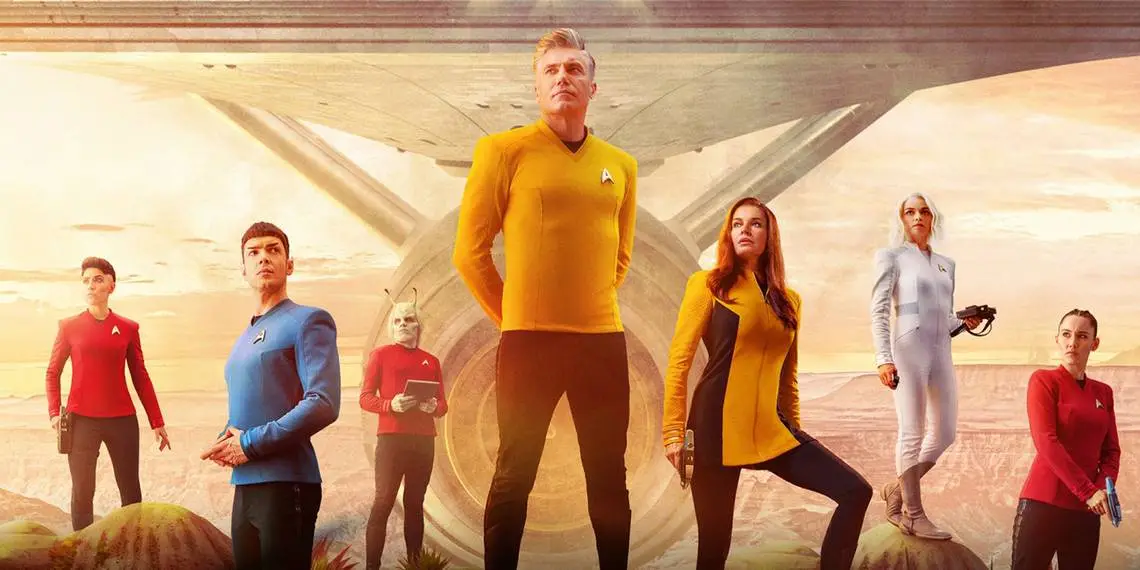 A promotional poster for the TV show 'Star Trek: Discovery' featuring seven crew members in their uniforms standing on a…