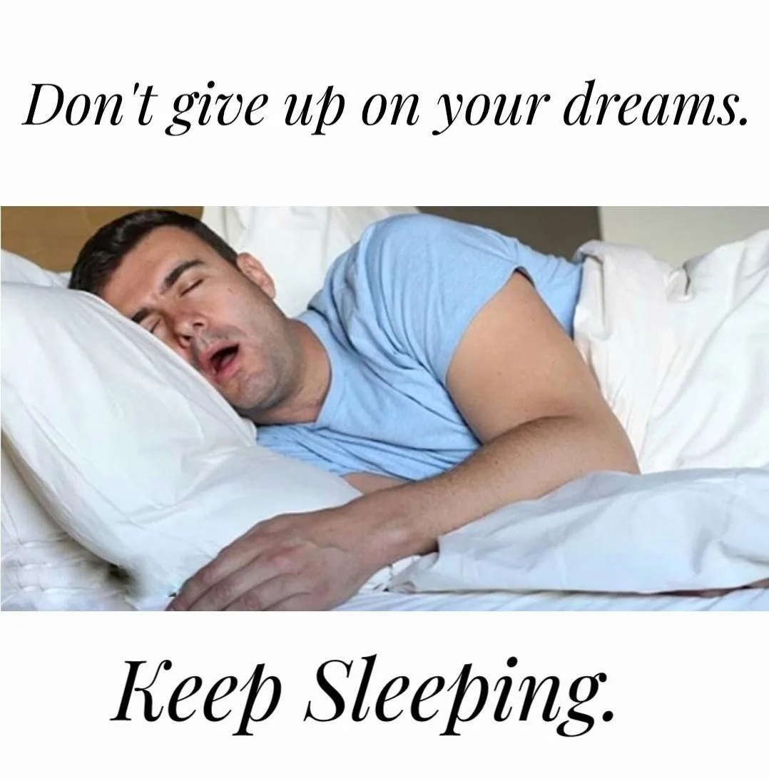 A man is sleeping in bed, mouth open, under white sheets and pillows, with the text 'Don't give up on your dreams.' above…