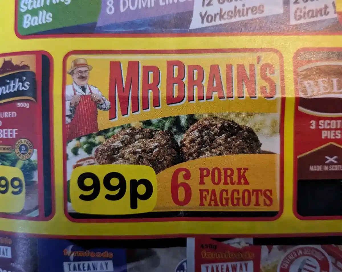 A close-up of a supermarket frozen food package for 'Mr Brain's' brand, showing a cartoon chef and two pork faggots, with a…