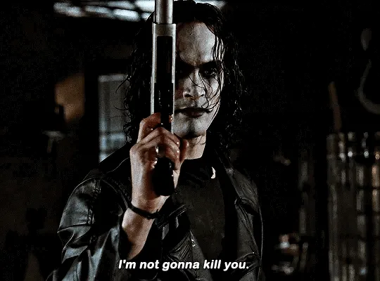 The image shows a still of the character The Joker from the movie 'The Dark Knight', holding a gun in a dark…