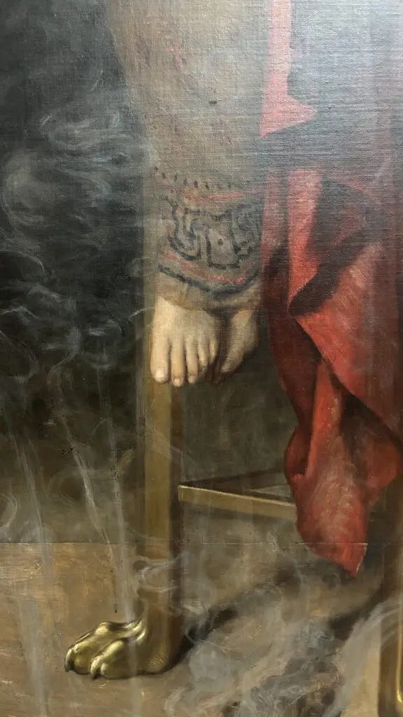 A close-up of a classical painting shows a human foot resting on a golden, clawed leg of a chair, with swirling smoke rising…