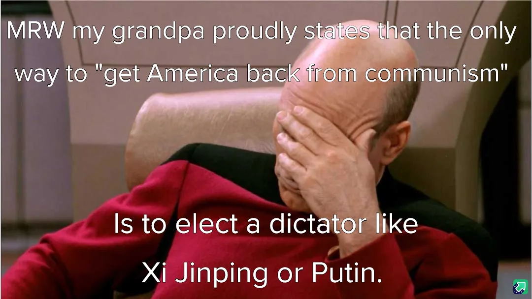 A bald man in a red uniform sits in a chair, covering his face with his hand in a gesture of despair or embarrassment. White…