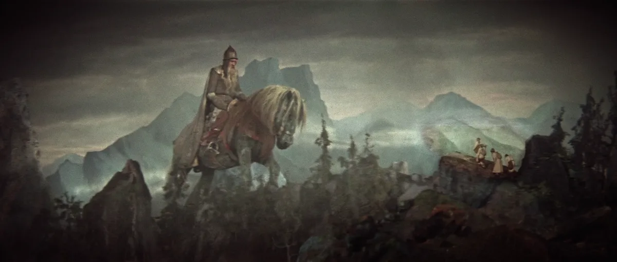 A dramatic, misty mountain scene features a large, bearded man in armor riding a horse atop a rocky peak, while three…