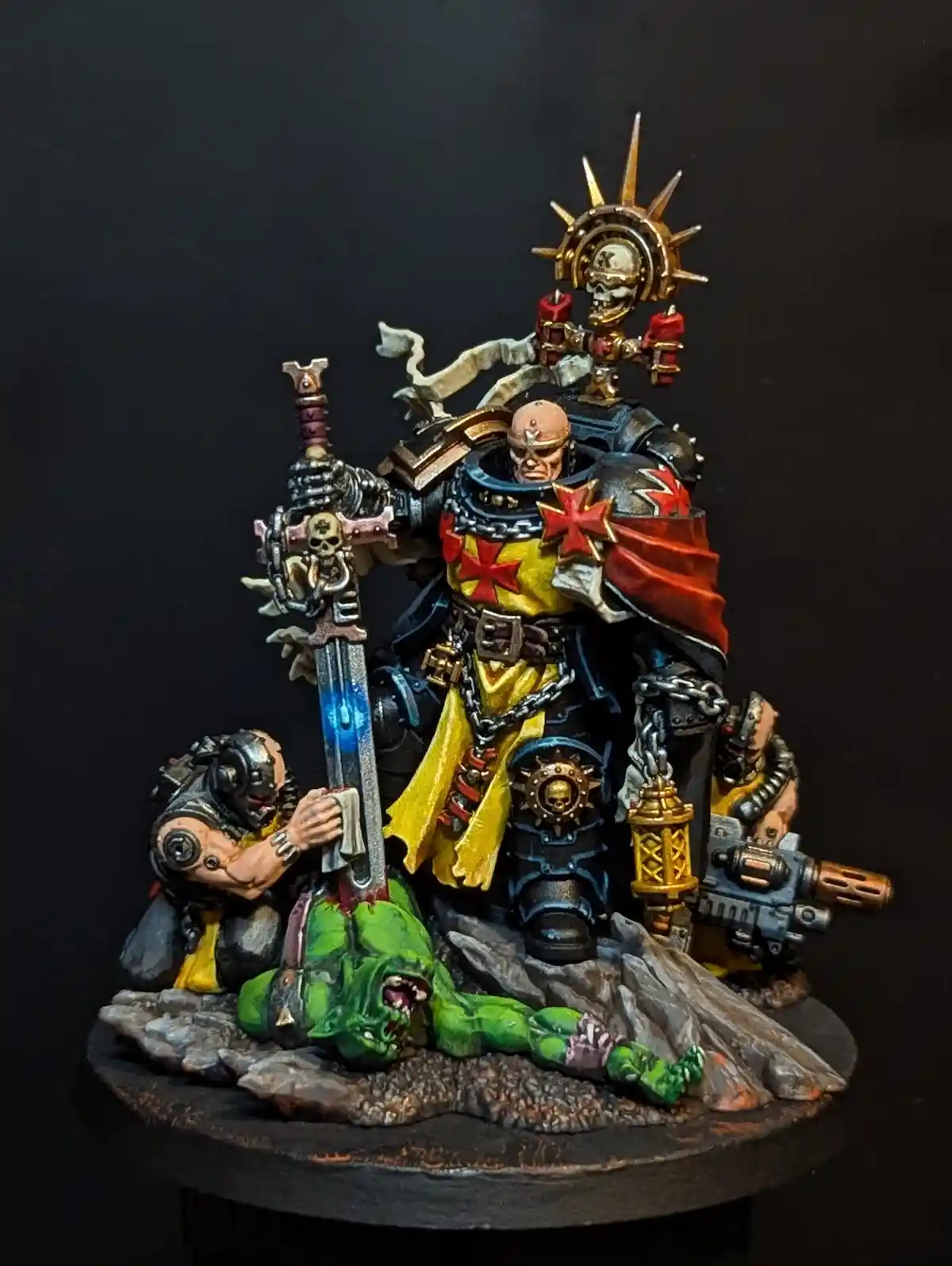 A painted miniature of a grimdark fantasy warrior in ornate armor, holding a glowing sword, with two smaller figures…