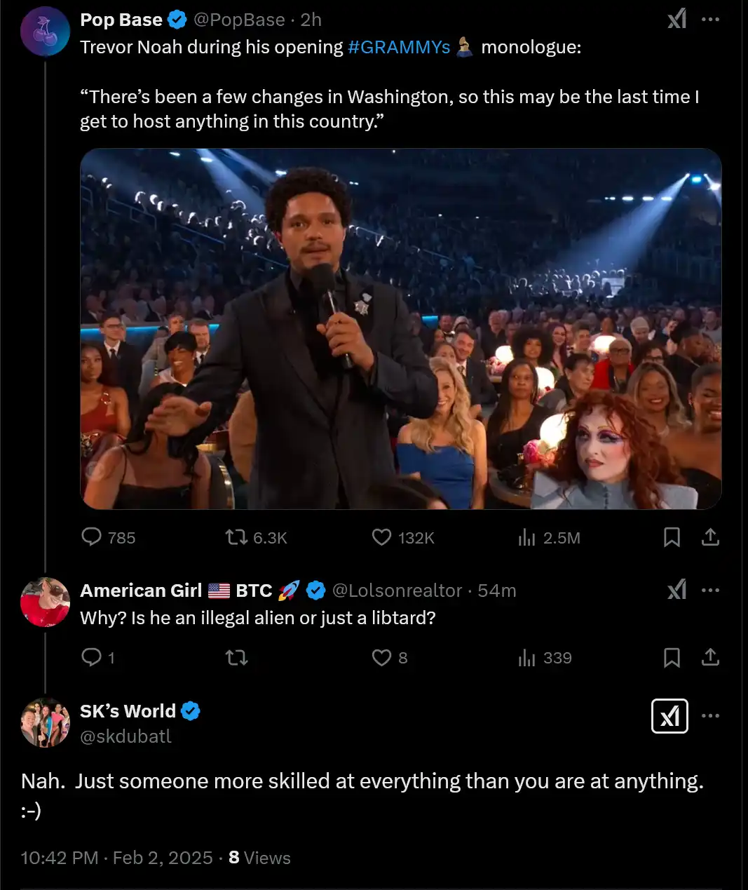 A screenshot of a tweet showing Trevor Noah on stage at the Grammys holding a microphone, with an audience behind him. The…