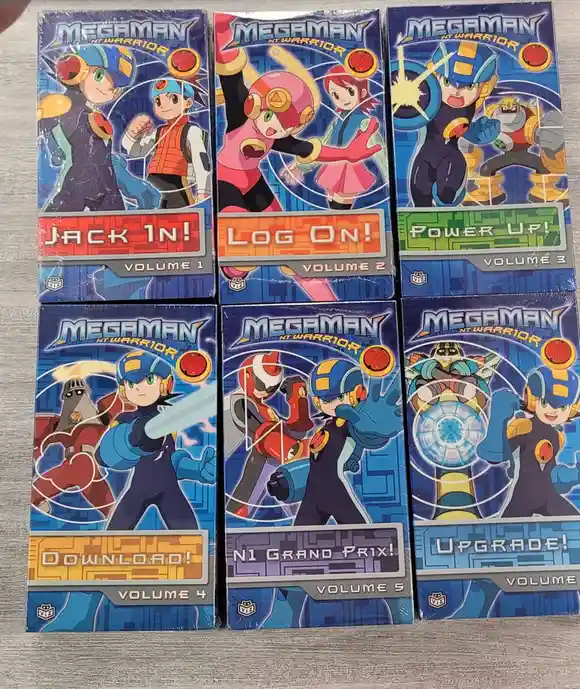 Six sealed 'MegaMan NT Warrior' trading card game booster boxes arranged in two rows, each labeled with a computer-themed…