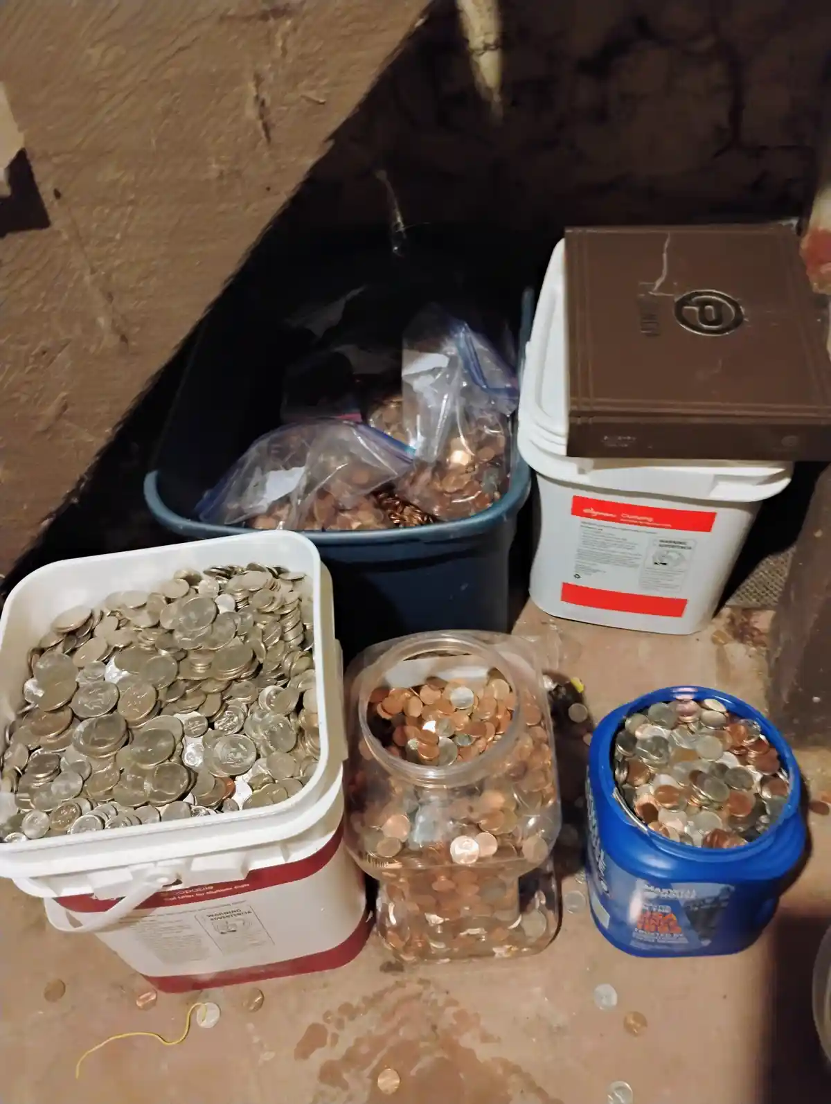 Several household containers, including a white bucket, a glass jar, and a blue container, are filled with various U.S…