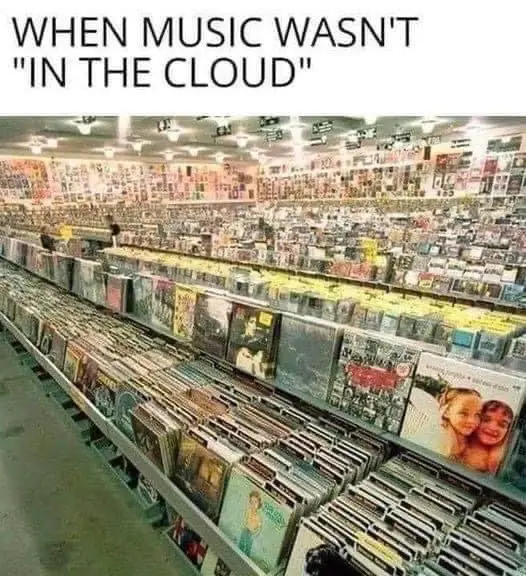 An overhead view of a massive record store filled with endless rows of vinyl records and cassette tapes on shelves…