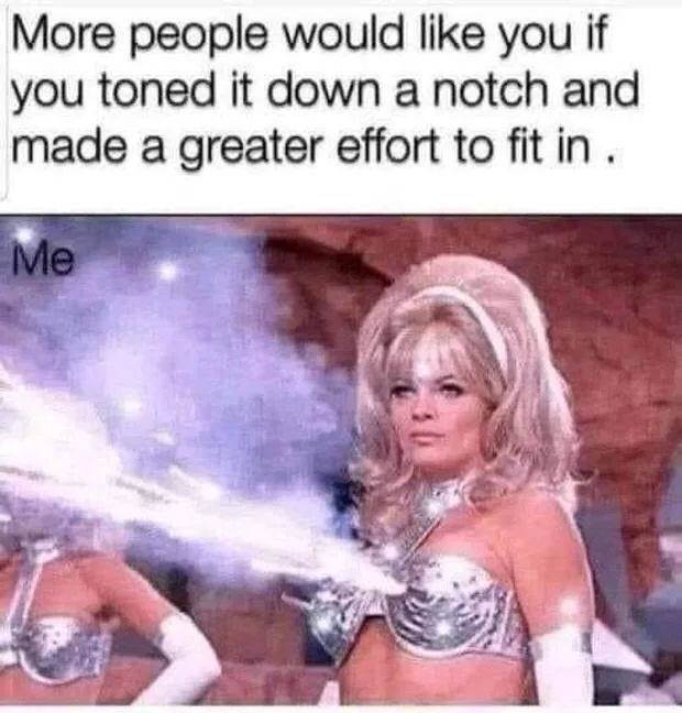 A woman in a silver, futuristic costume with a large, voluminous blonde wig stands confidently, firing a beam of light from…