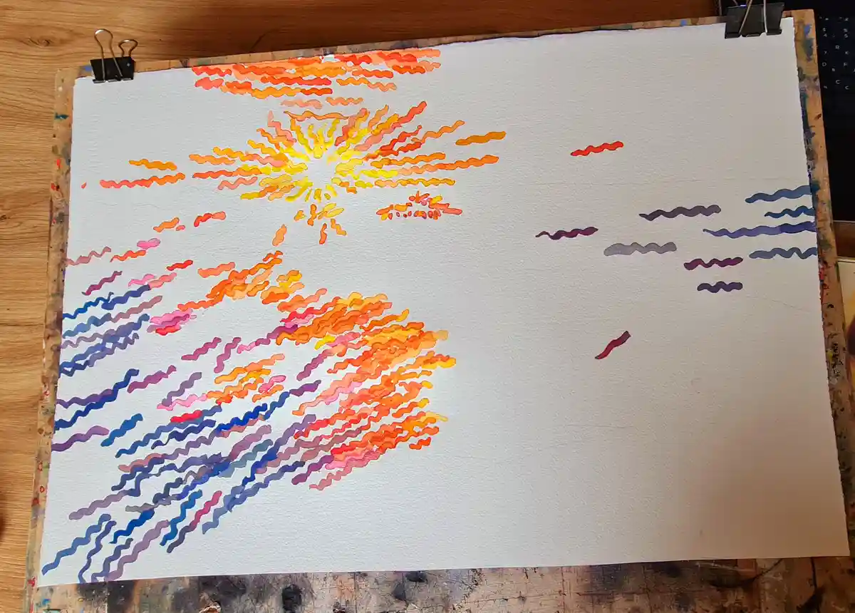 A watercolor painting on white paper depicts a sunset with wavy, colorful strokes in orange, yellow, pink, and blue, but the…