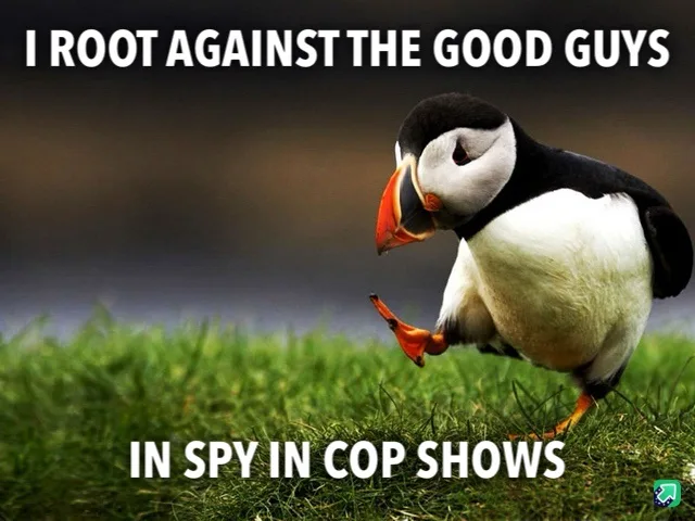 A puffin stands on green grass, looking down with one foot slightly lifted, as if in contemplation or mild disdain. White…