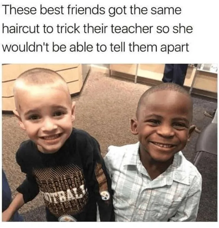 Two young boys with nearly identical buzz cuts are smiling at the camera. The boy on the left wears a black t-shirt with…
